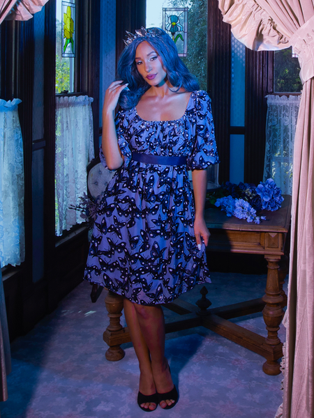 Vanessa pushes her hair out of her face while sultrily gazing into the camera and wearing Tim Burton's CORPSE BRIDE™ Butterfly Babydoll Dress in Dusk Blue.