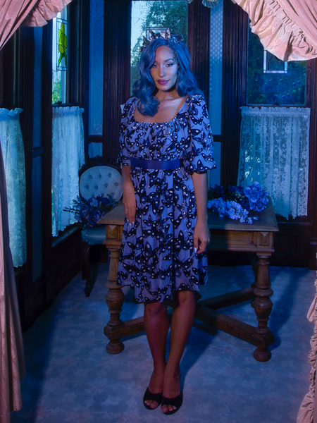 Vanessa looks into the camera while wearing the Tim Burton's CORPSE BRIDE™ Butterfly Babydoll Dress in Dusk Blue from goth dress company La Femme en Noir.