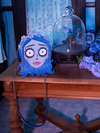 The Tim Burton's CORPSE BRIDE™ Emily Bag next to a blue bouquet of flowers.