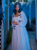 Vanessa looks down at the ground while wearing Tim Burton's CORPSE BRIDE™ Emily Butterfly Gown in Celestial Blue from goth glamour clothing company La Femme en Noir.