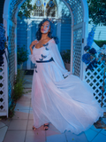 Vanessa looks into the camera while the white skirt of Tim Burton's CORPSE BRIDE™ Emily Butterfly Gown in Celestial Blue billows in the wind.