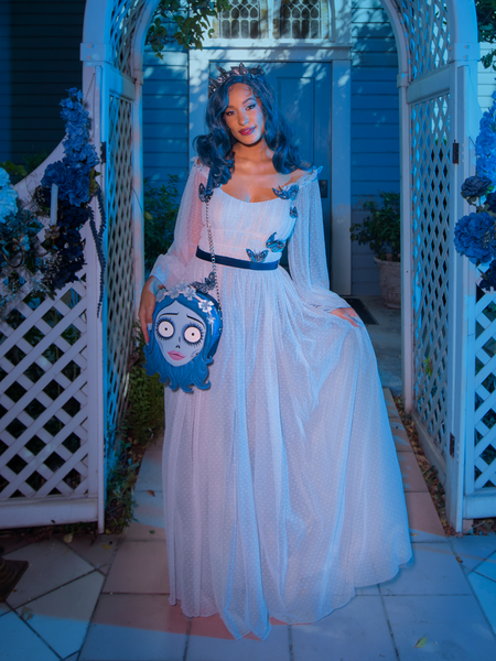 Model wears a flowy white dress while modeling the Tim Burton's CORPSE BRIDE™ Emily Bag hanging off of her shoulder.