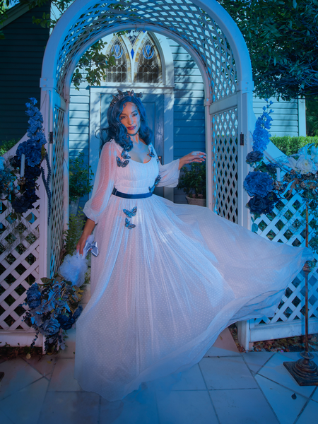 Vanessa twirls to show off the gorgeous white, intricately decorated fabric of Tim Burton's CORPSE BRIDE™ Emily Butterfly Gown in Celestial Blue from goth glamour clothing company La Femme en Noir.