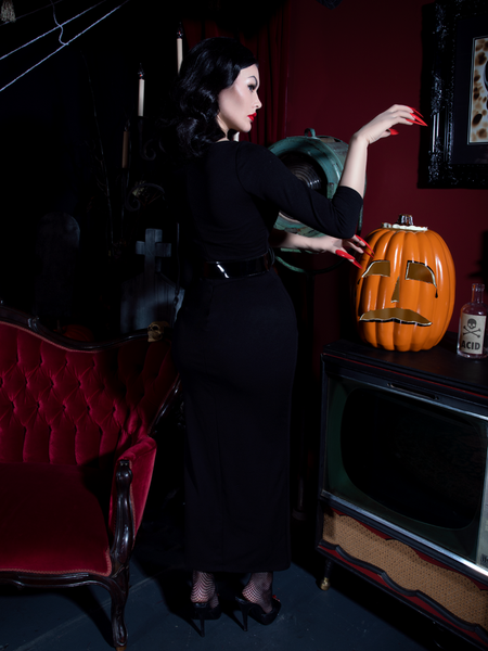 Heather Clarke striking a scary pose while facing away from the camera in the Glamour Ghoul Gown  from gothic glamour clothing brand La Femme en Noir.