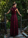 Aliza looking back while wearing the Mythical Goddess Gown in Oxblood Gorgon Print.