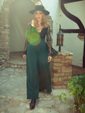Micheline Pitt walks out of a Tudor style home modeling the Black Widow palazzo pants in hunter green.