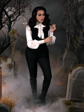 Adjusting the sleeves on her white, flowy shirt, Micheline Pitt shows off the Sleepy Hollow Ichabod Pants in Black.