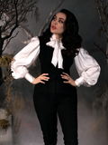 With her hands placed on her hips and looking off to the side, Micheline Pitt channels her inner Ichabod Crane while modeling the Victorian Blouse in Ivory from La Femme en Noir's Sleepy Hollow Collection.