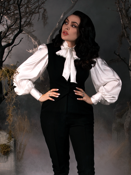 Micheline Pitt, standing with her hands on her hips, wearing the Sleepy Hollow Ichabod Vest in Black from gothic clothing retailer La Femme en Noir.