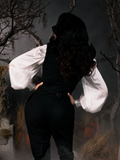 Turned away from the camera, Micheline Pitt shows off the back of the Sleepy Hollow Ichabod Vest in Black from gothic retro clothing company La Femme en Noir.