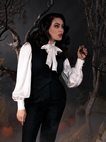 Micheline Pitt standing while slightly turned to the side in the Sleepy Hollow Ichabod Vest in Black.