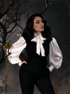 Micheline Pitt standing with her hands tucked into her pants shows off the Sleepy Hollow Ichabod Vest in Black.