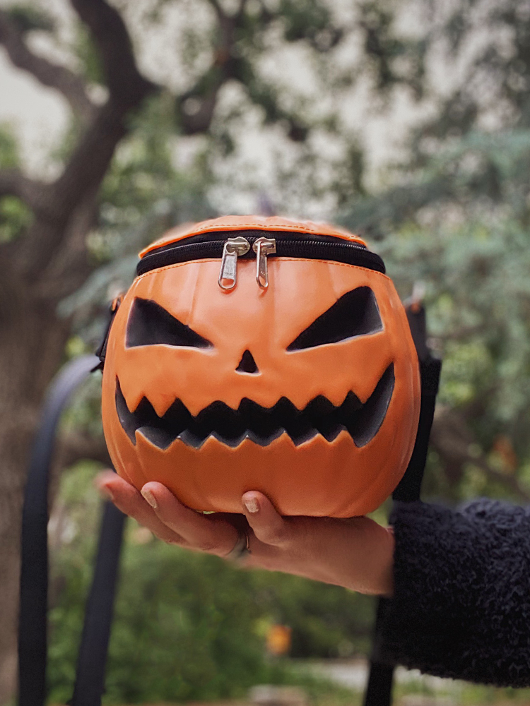 The Sleepy Hollow Baby Pumpkin Bag being held in the palm of a model's hand.