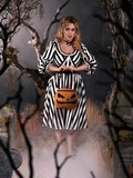 Linda holding the Sleepy Hollow Pumpkin Bag, walks through a foggy graveyard.
