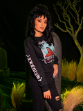 Female model wearing the BEETLEJUICE™ Lydia Strange Long Sleeve Tee with a pair of black ripped jeans.
