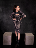 Full length image of Micheline Pitt standing in an Aliens inspired dress and the Platelet Harness in Black Faux Leather.