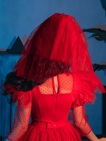 The back of the Tulle Veil in Red paired with a red retro style dress - all items from La Femme en Noir.
