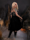 With her back towards the camera while looking over her shoulder, Micheline Pitt models the Sleepy Hollow Gothic Tales Velour Skirt in Black from La Femme En Noir.