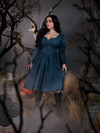 Rachel looks down and off while showing off the Sleepy Hollow The Lady Crane Dress in Vintage Blue from La Femme en Noir.