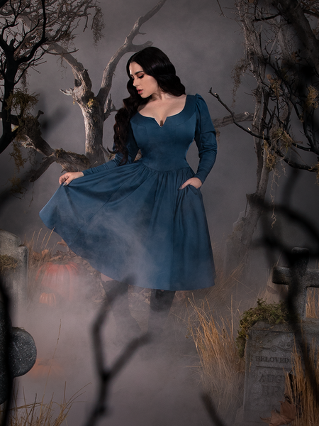 Rachel posing in a haunted graveyard scene while wearing a gothic style retro dress inspired by the Sleepy Hollow film from Tim Burton.