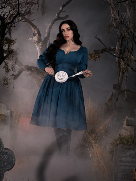 Rachel holding a small purse, also from the Sleepy Hollow collection, to compliment her Sleepy Hollow The Lady Crane Dress in Vintage Blue dress.