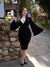 Rachel posing with her arms outstretched while wearing a gothic retro clothing outfit.