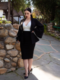 Rachel Sedory standing on a stone driveway wearing the Metropolis Suit Skirt in Black.