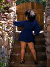 A back shot of Ashleeta, standing on stairs, modeling the Black Widow Tap Shorts in Navy.