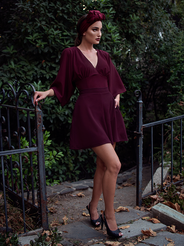 Aliza, with her hand in her pocket, models the Black Widow tap shorts in oxblood by La Femme En Noir.