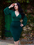Rachel looks off in the distance while modeling the Vamp Pencil Skirt in Dark Green from gothic retro clothing company La Femme en Noir.