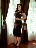 Rachel standing in front of a window modeling the Vamp pencil skirt in black by La Femme En Noir.