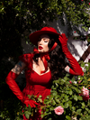 The Faux Leather Opera Gloves in Crimson worn by Micheline Pitt along with matching hat and low-cut dress. All gothic style clothes features here are available from La Femme en Noir.