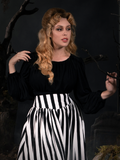 Linda photographed in her gothic retro outfit featuring a black and white striped skirt and black goth top.