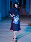 Raven haired model shows off the Tim Burton's CORPSE BRIDE™ Emily Bag slung over her shoulder to compliment her dark navy blue gothic retro dress.