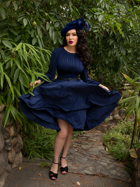 Caught mid-twirl while wearing the Salem Dress in Navy, Micheline Pitt channels her inner gothic retro style.