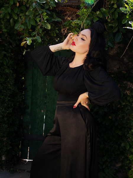 Micheline Pitt standing in an all-black gothic style outfit from La Femme en Noir.