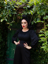 With her hands on her hips, Micheline shows off her gothic retro clothing outfit including the Salem Top in Black.