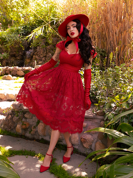 Micheline Pitt wearing the Southern Gothic Skirt in Crimson with a matching colored top, shoes and hat.