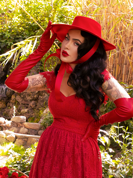 Micheline Pitt slightly turned to the side while wearing the Southern Gothic Bustier Top in Crimson from gothic glamour clothing company La Femme en Noir.