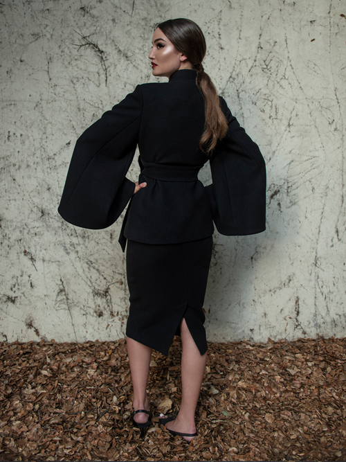 Aliza turned away from the camera to show off the back of the Metropolis Suit Skirt in Black from La femme en Noir.