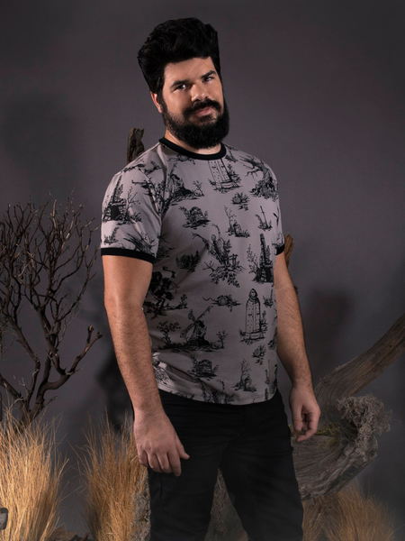 Looking into the camera while standing in a foggy forest setting, R.H. Norman models the Sleepy Hollow™ Toile Ringer Tee by La Femme En Noir.