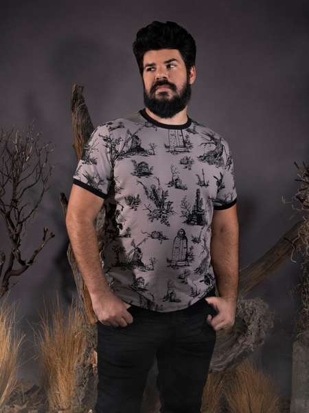 Looking away from the camera with his hands in his pockets, R.H. Norman models the Sleepy Hollow™ Toile Ringer Tee from La Femme En Noir.