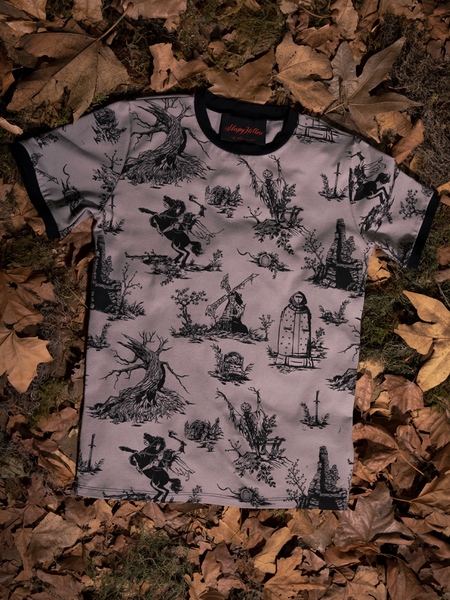 A closeup image of the gothic style clothing Sleepy Hollow™ Toile Ringer Tee on the ground with dead leaves.