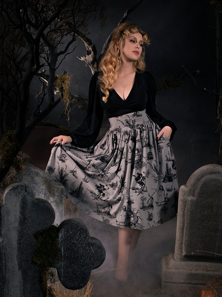 Linda showing off her gothic retro clothing outfit while standing in a foggy graveyard amongst tombstones.