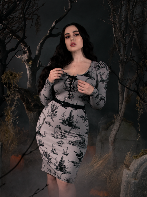 Model Rachel Sedory standing in a foggy cemetery wearing a grey goth dress inspired by Sleepy Hollow. 