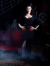 Heather Clark with her hands on her hips wearing the Vampira® Show Gown from gothic clothing brand La Femme en Noir.