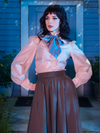 Stephanie with her hands resting on her sides, shows off the flowy sleeves of the Edwardian Blouse With Cravat.