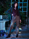 Full length shot of Stephanie standing in outdoor garden setting while wearing the Tim Burton's CORPSE BRIDE™ Victor Peplum Blazer in Spruce Green.