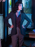 Stephanie posing with her hands on her hips and looking off to the side while wearing Tim Burton's CORPSE BRIDE™ Victor Peplum Blazer in Spruce Green from gothic retro clothing brand La Femme en Noir.