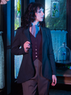 Waist level shot of Stephanie turned to the side while pulling on the lapel of the Tim Burton's CORPSE BRIDE™ Victor Peplum Blazer in Spruce Green.
